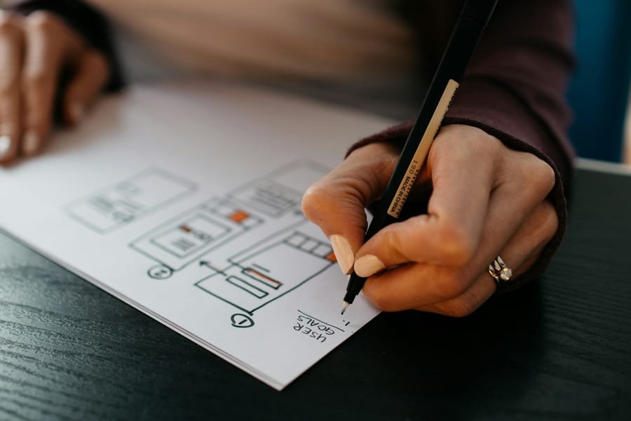 Hand sketching a mobile app wireframe on paper